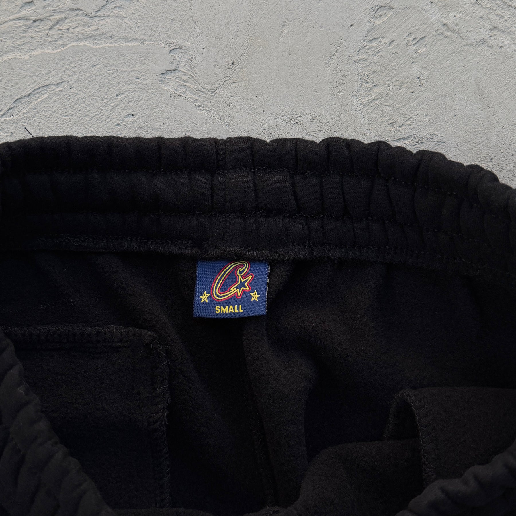 Conjunto Corteiz “Lion Varsity Open Hem Zip”