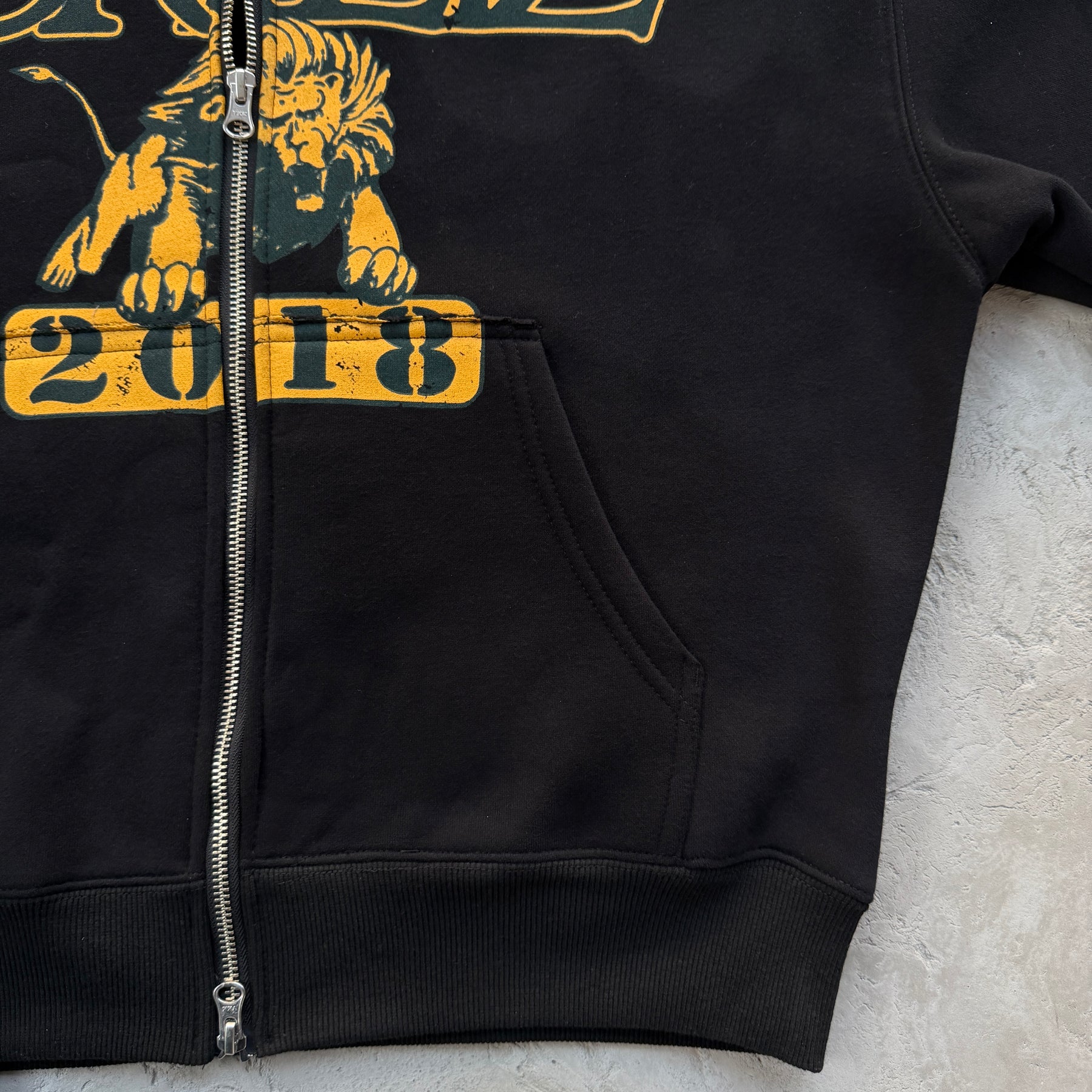 Conjunto Corteiz “Lion Varsity Open Hem Zip”